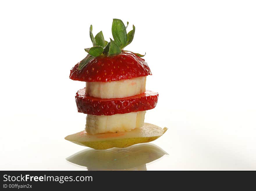 Slices of a strawberry, pear and banana on a white background