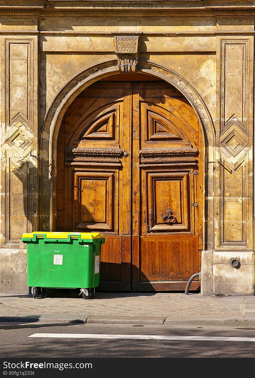 Grunge wooden door with bronze handles in Paris