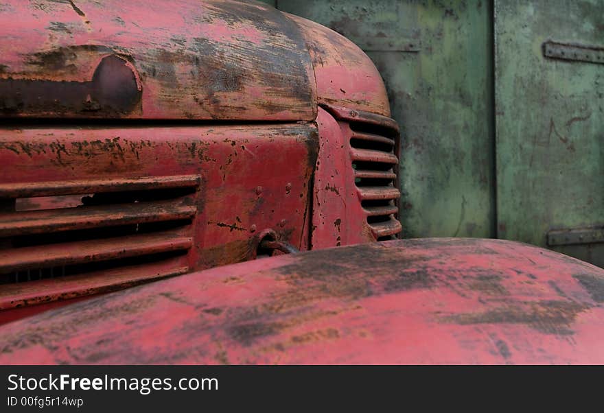 Old red truck standing against green door background