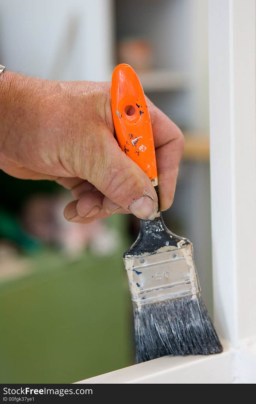 Craftsman restaurates a window with his paintbrush. Close-Up of Paintbrush and hand. Craftsman restaurates a window with his paintbrush. Close-Up of Paintbrush and hand.