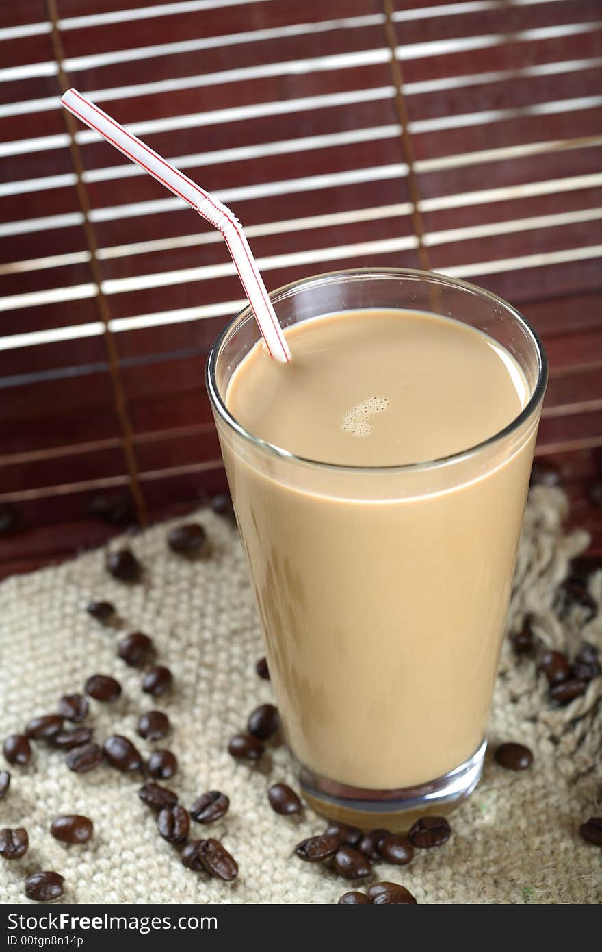 A cold coffee with milk and straw. A cold coffee with milk and straw