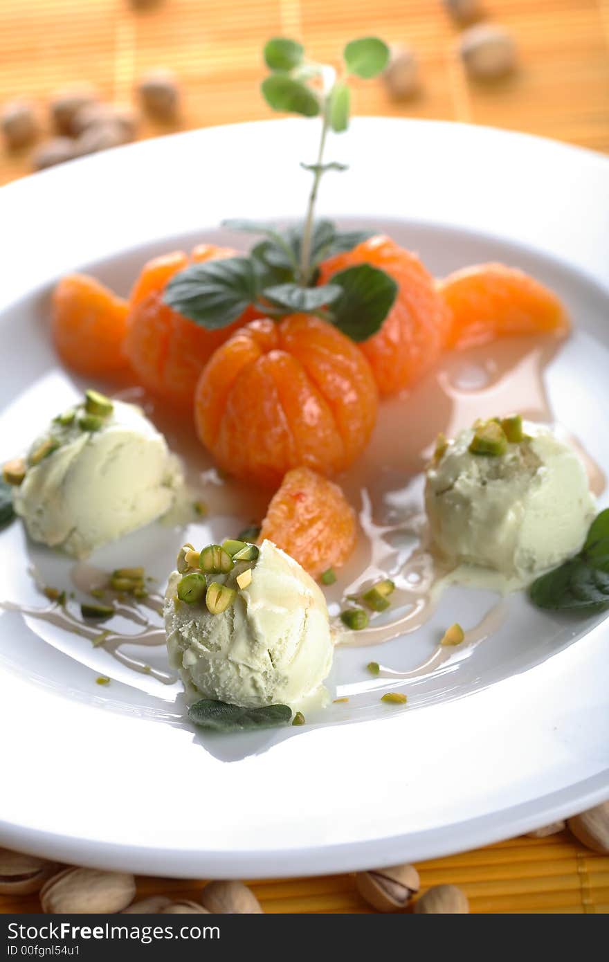 Hot tangerines with pistachio ice cream on the plate