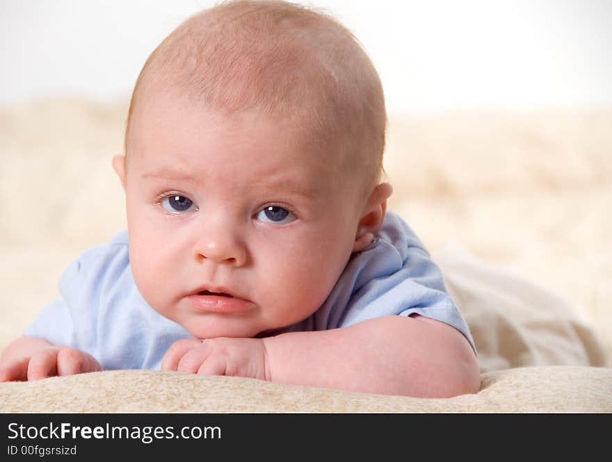 New born baby in blue posing on bed. New born baby in blue posing on bed