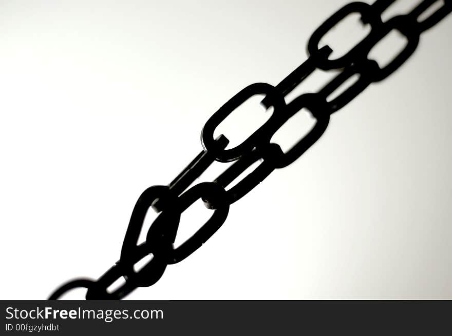 A dark metal chain with light background