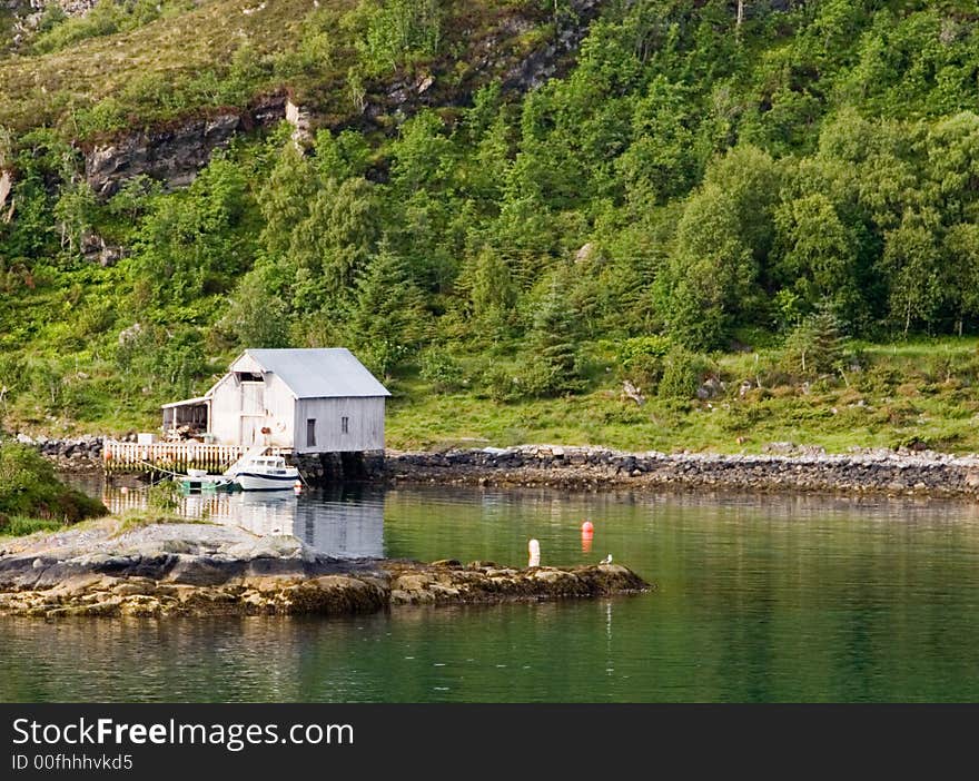 This is a summer house along the Norwegian coast with a small harbor for a boat. This is a summer house along the Norwegian coast with a small harbor for a boat