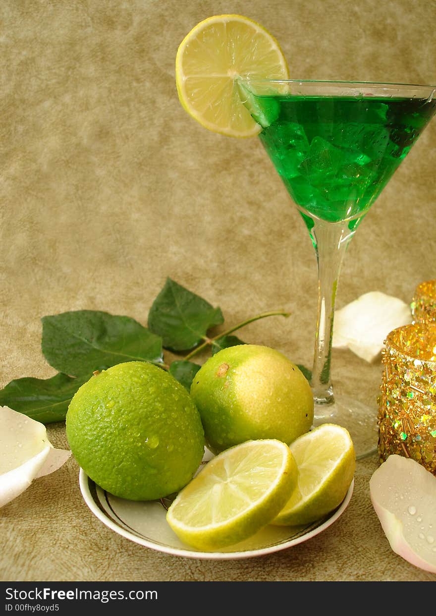 Martini glass with limes on a plate and candles