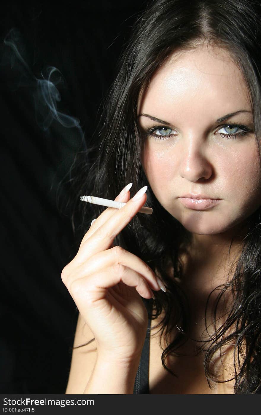 Young girl in black top with cigarette. Young girl in black top with cigarette