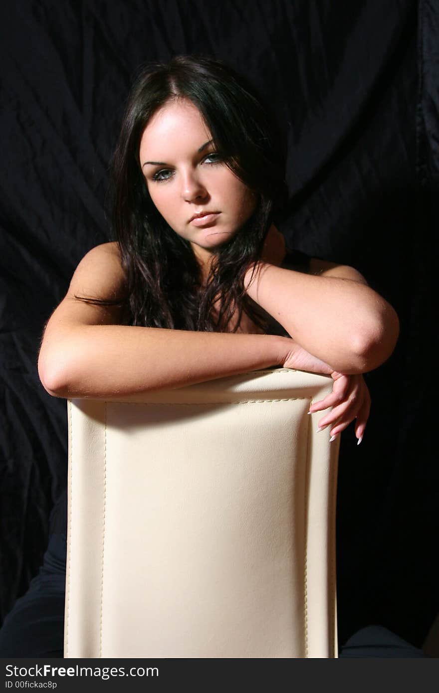 Young girl in black top on the chair. Young girl in black top on the chair