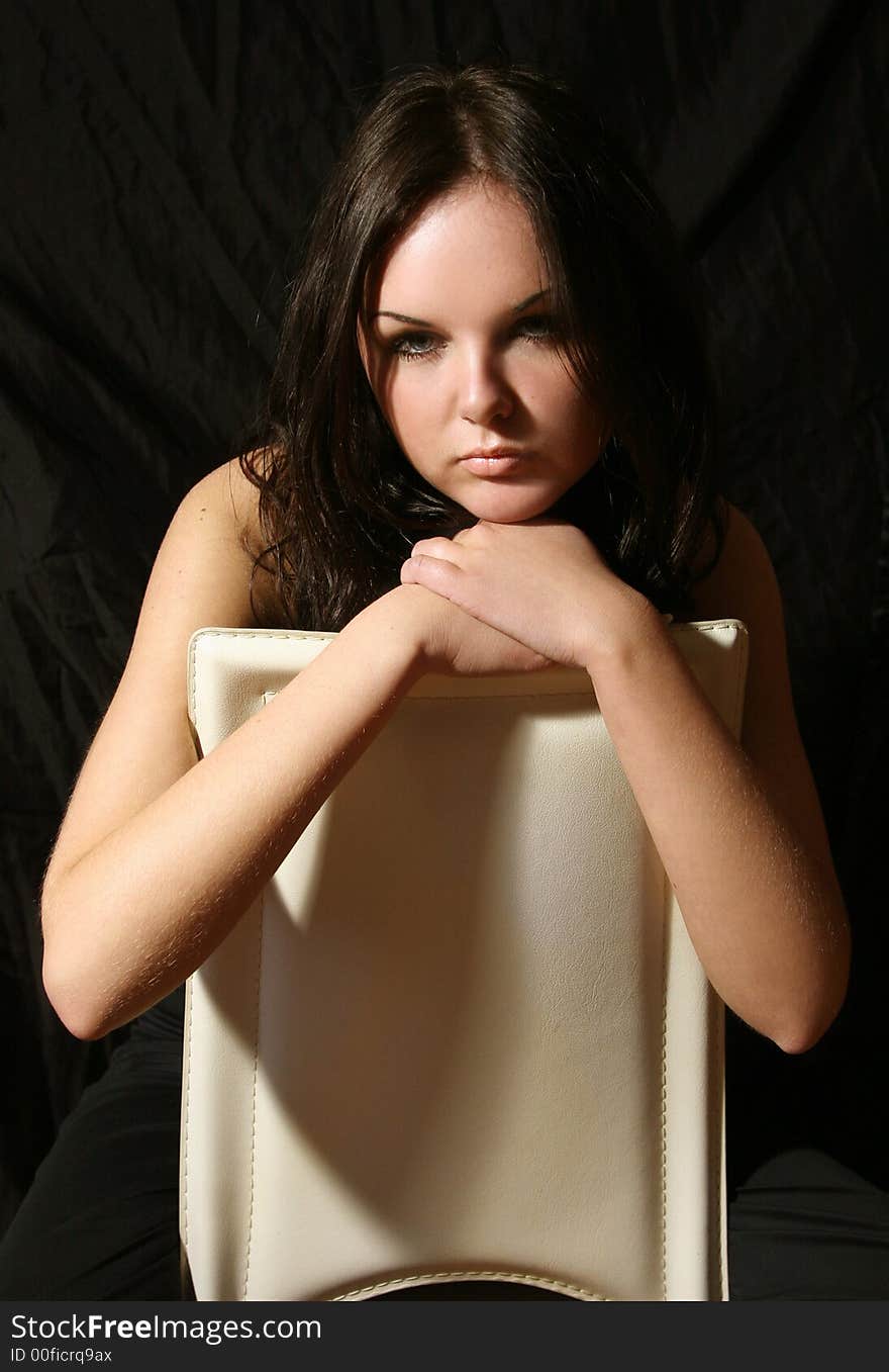 Young girl in black top on the chair. Young girl in black top on the chair