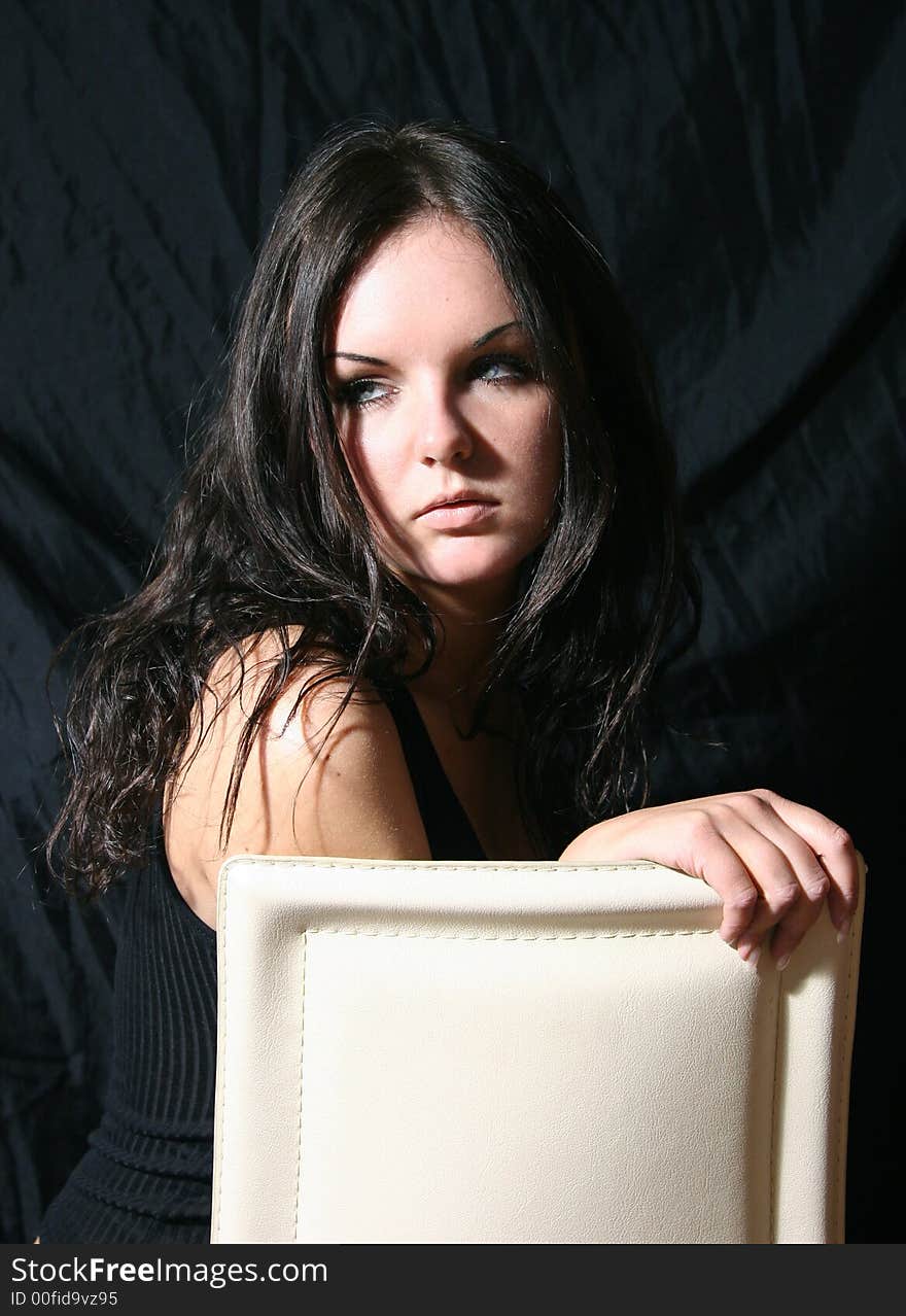 Young girl in black top on the chair. Young girl in black top on the chair