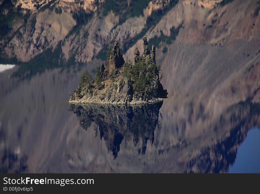 Phantom ship island. Island and mountain reflection in water. Crater lake