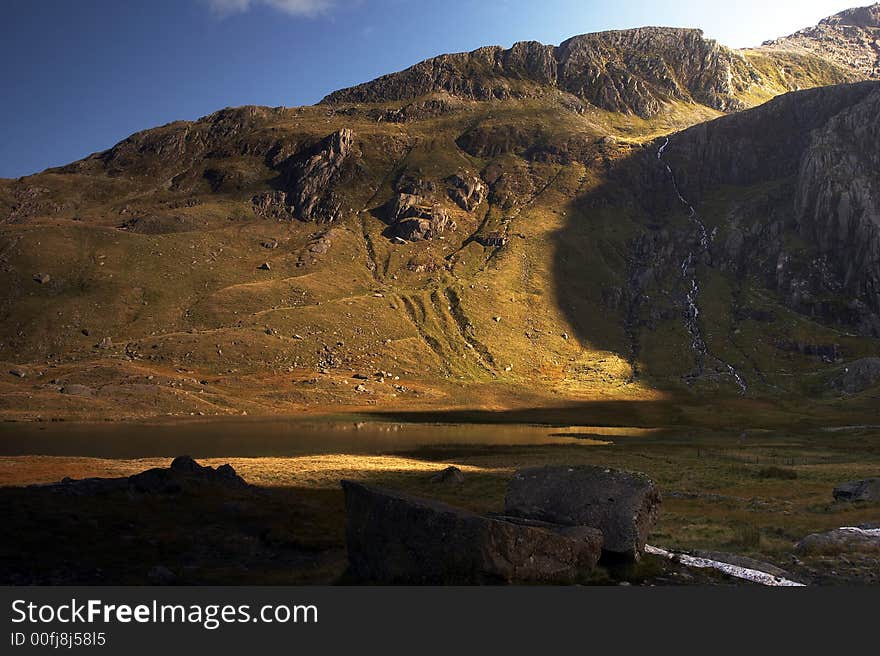 Llyn Idwal in the Snowdonia National Park bathed in golden sunlight. Llyn Idwal in the Snowdonia National Park bathed in golden sunlight.