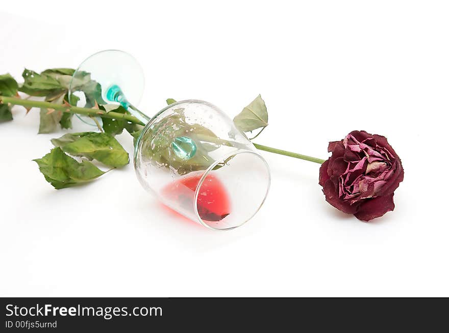 Red wine in a glass and a dried up rose. Red wine in a glass and a dried up rose