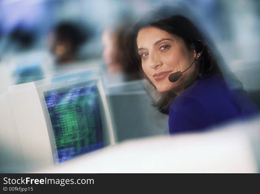 Businesswoman with telephone headset at computer. Businesswoman with telephone headset at computer