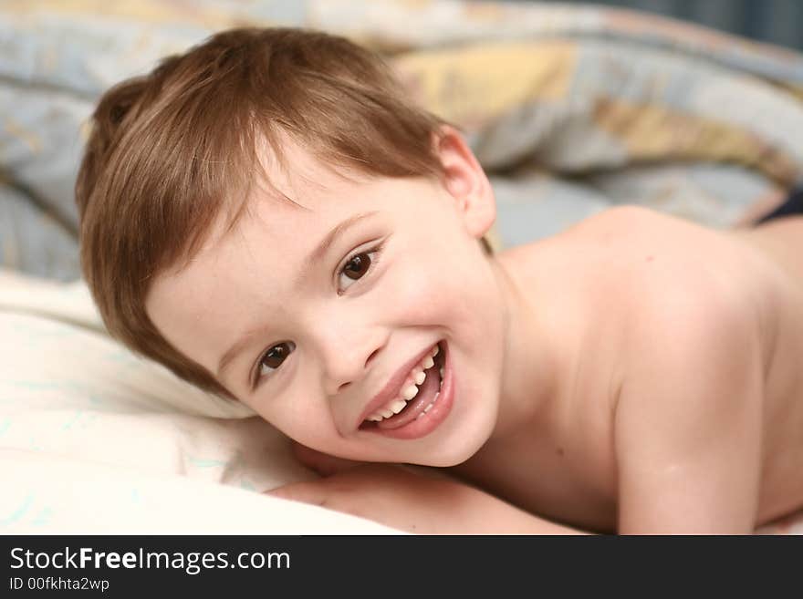 The cheerful child lays on a sofa