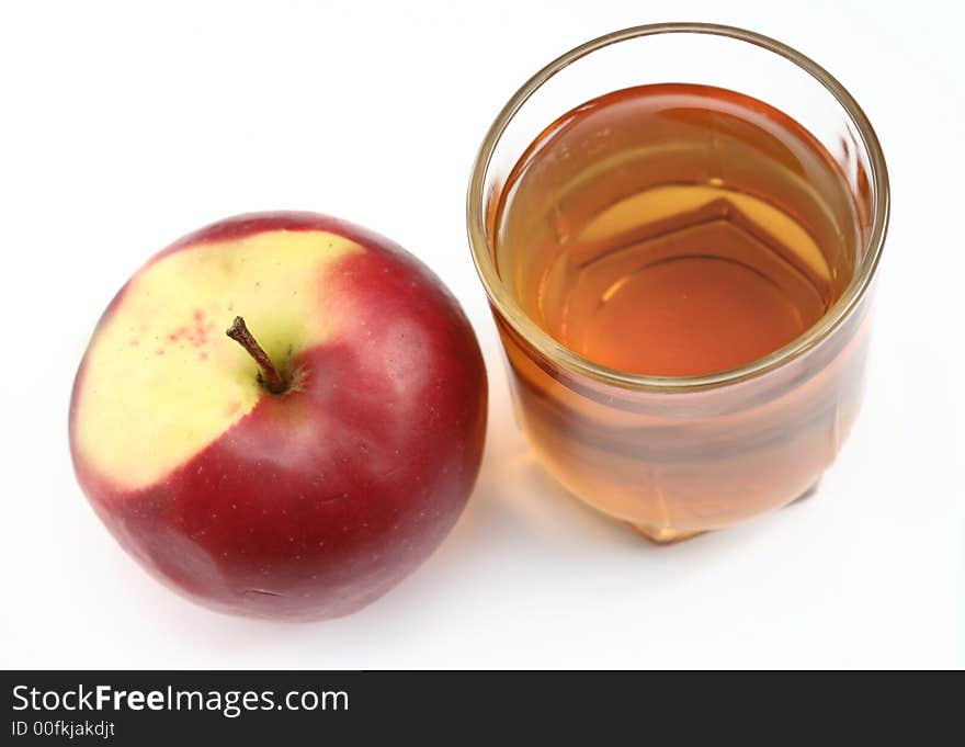 Red apple and glass of juice on a white background