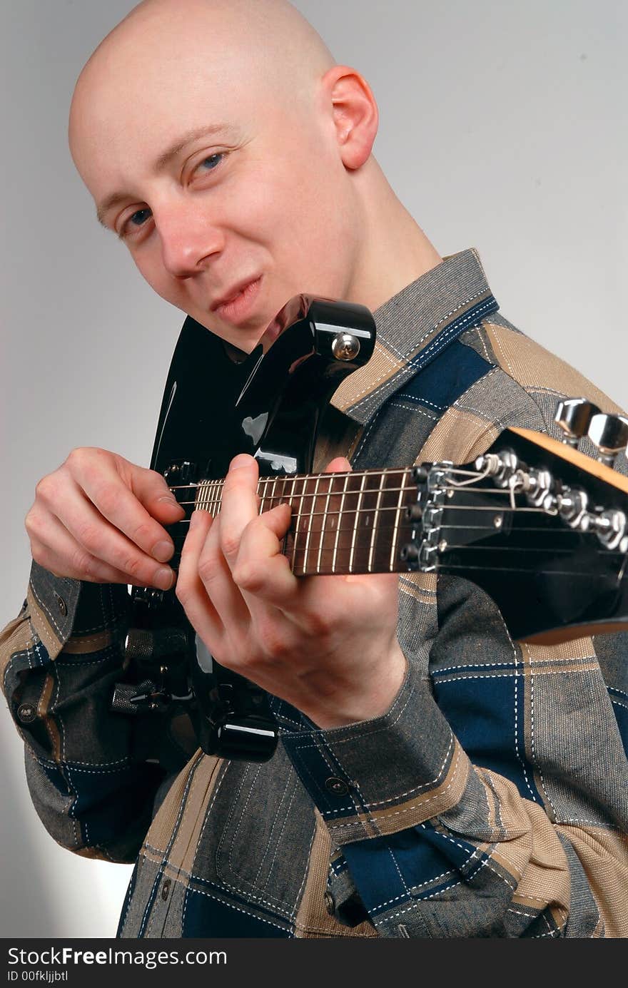 The musician with a guitar on a grey background