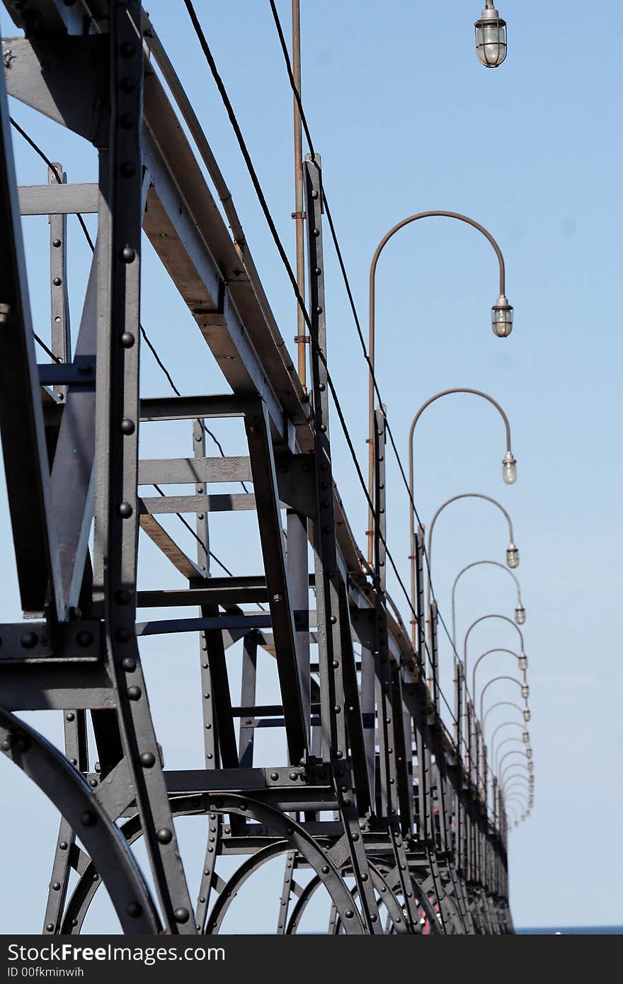 Curved bars provide lights over a long pier. Curved bars provide lights over a long pier