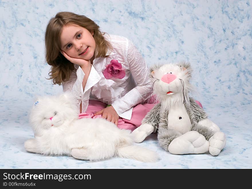 The girl with toys smiles on a blue background