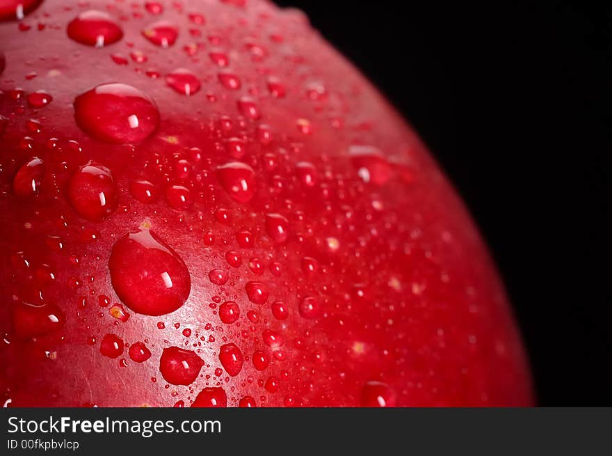 Close-up of red apple with water drops; black background. Close-up of red apple with water drops; black background