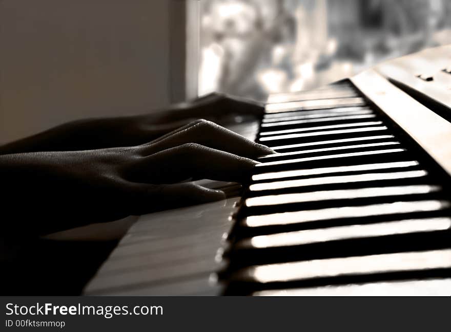 Child practicing on the keyboard in sepia