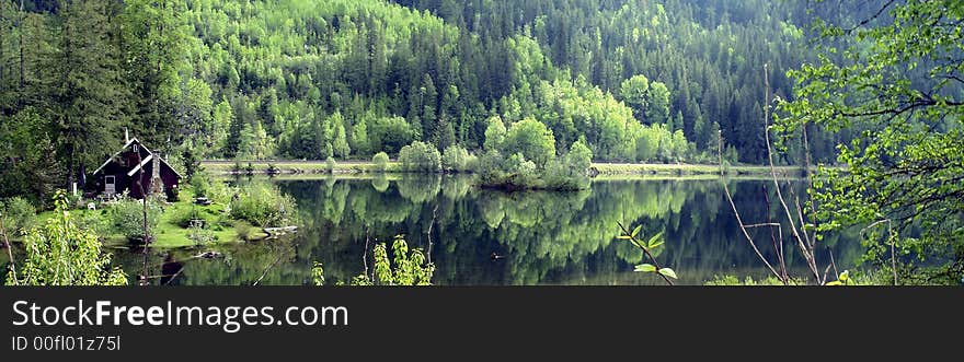 Rustic cabin and spring foliage at Three Valley Lake south of Revelstoke, British Columbia. Rustic cabin and spring foliage at Three Valley Lake south of Revelstoke, British Columbia