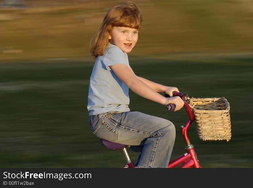 Girl riding bike in the park, motion blur background. Girl riding bike in the park, motion blur background