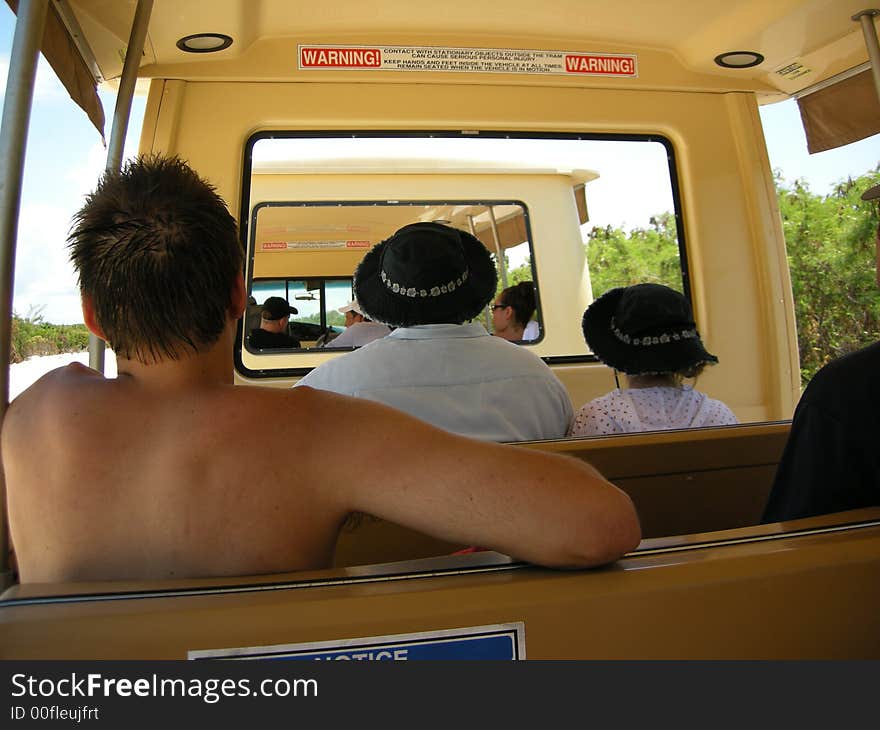 Picture taken on a tram ride showing the backs of the riders with various vacation attire. Picture taken on a tram ride showing the backs of the riders with various vacation attire.