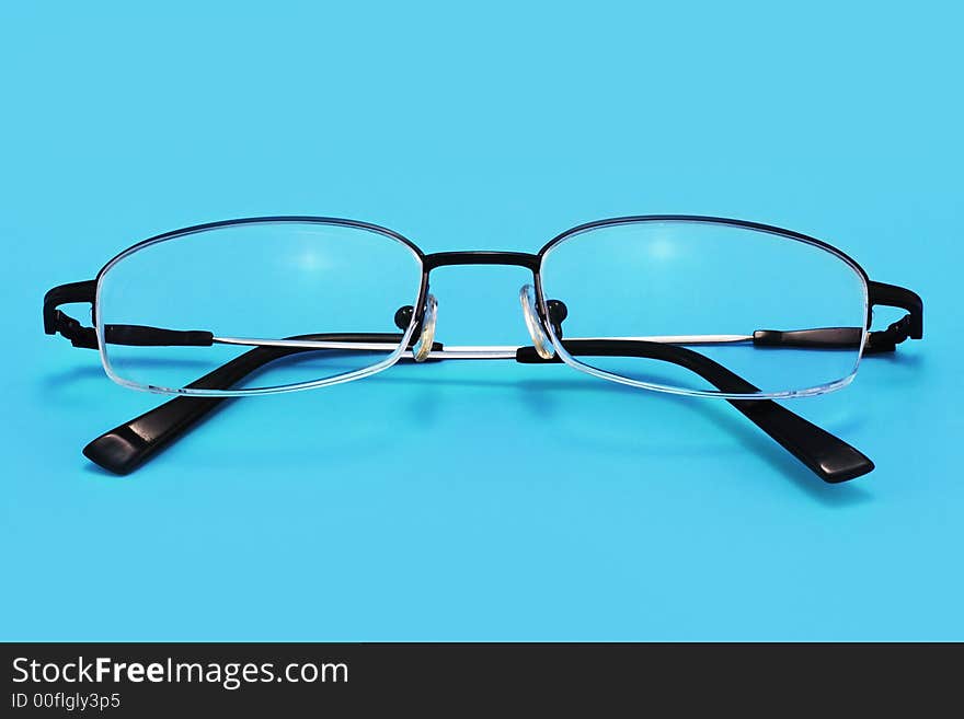 Eyeglasses on a blue background with smooth shadow. Eyeglasses on a blue background with smooth shadow