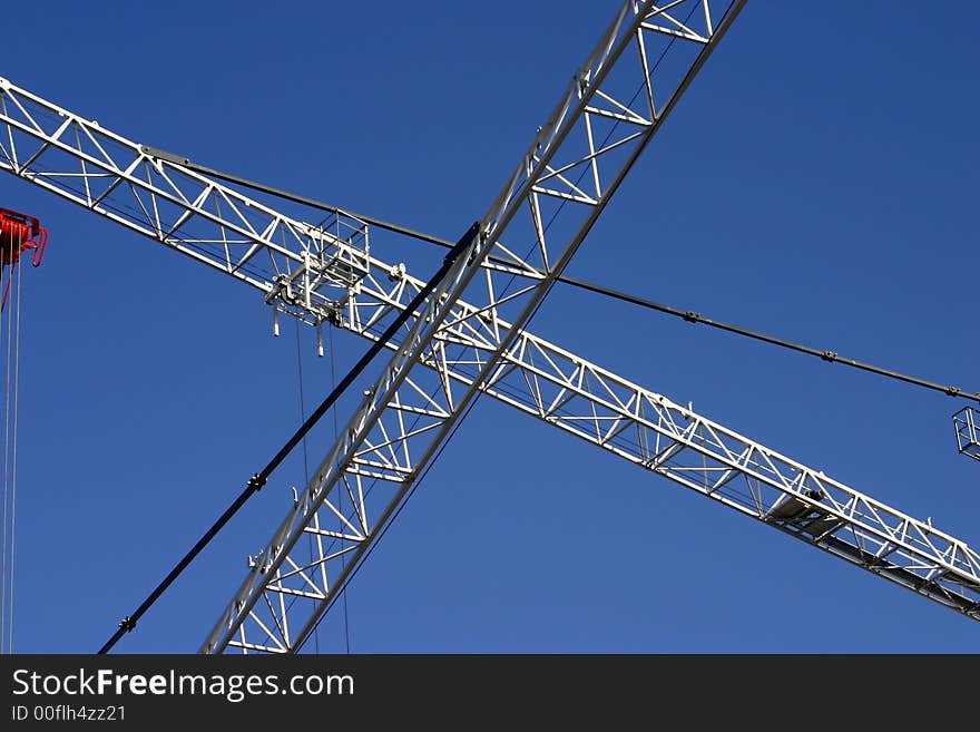 View at crossed cranes on a blue sky