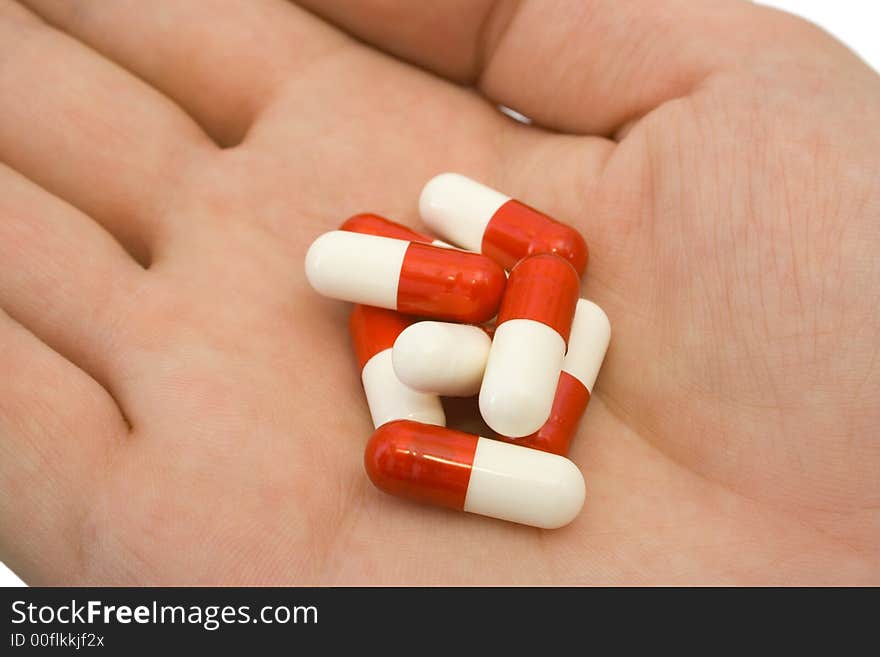 Pills on hand, close-up, isolated on white background