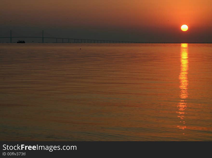 Tampa bay sunset and boat passing through bridge. Tampa bay sunset and boat passing through bridge