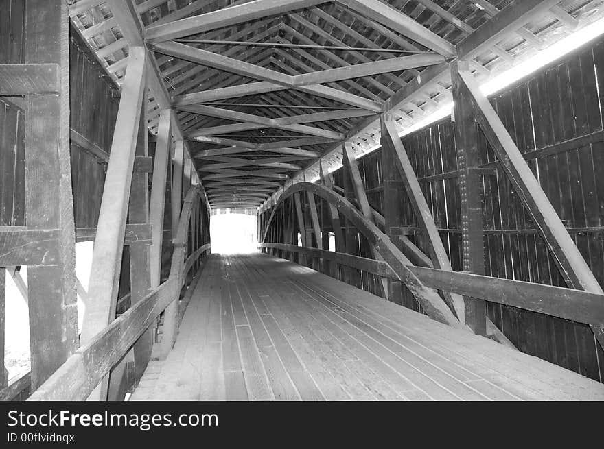 A black and white pic looking inside a covered bridge. A black and white pic looking inside a covered bridge