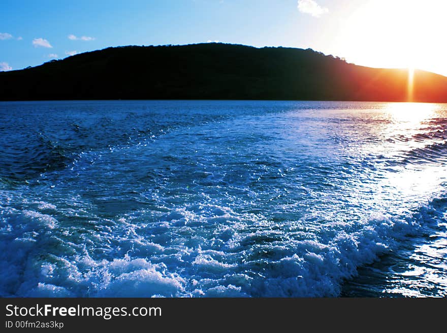 Sunset over an island with blue water. Sunset over an island with blue water