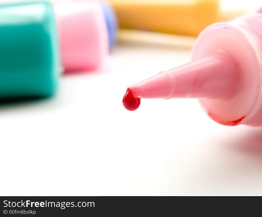 Tube of a red paint with red drop on white background