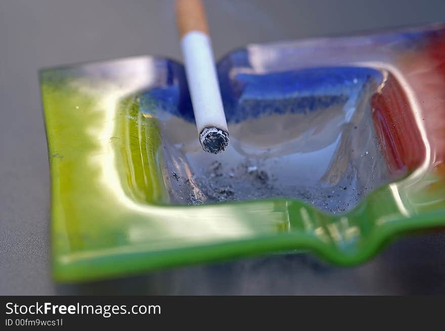 Close-up of a cigarette and an ash-tray. Close-up of a cigarette and an ash-tray.