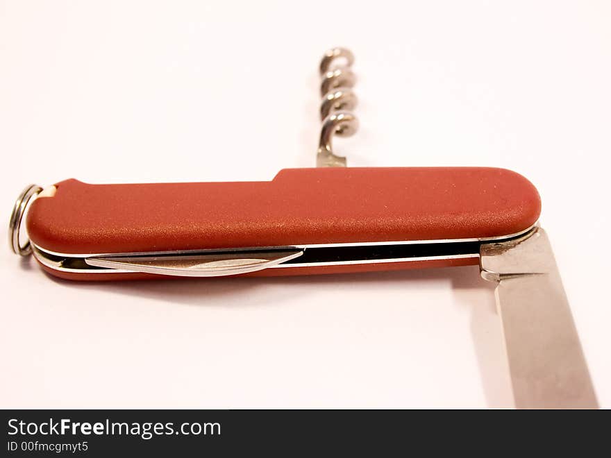 Red pen-knife with steel edge over wgite background