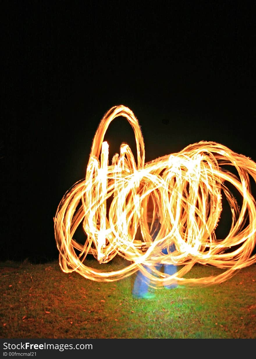 A fire dancer with fire trails creating beautiful effect