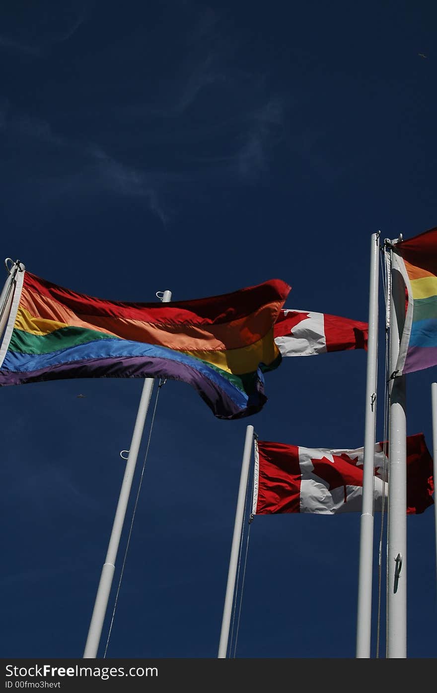 Canadian and gay pride flags fly together over English Bay, Vancouver, British Columbia, Canada. Canadian and gay pride flags fly together over English Bay, Vancouver, British Columbia, Canada