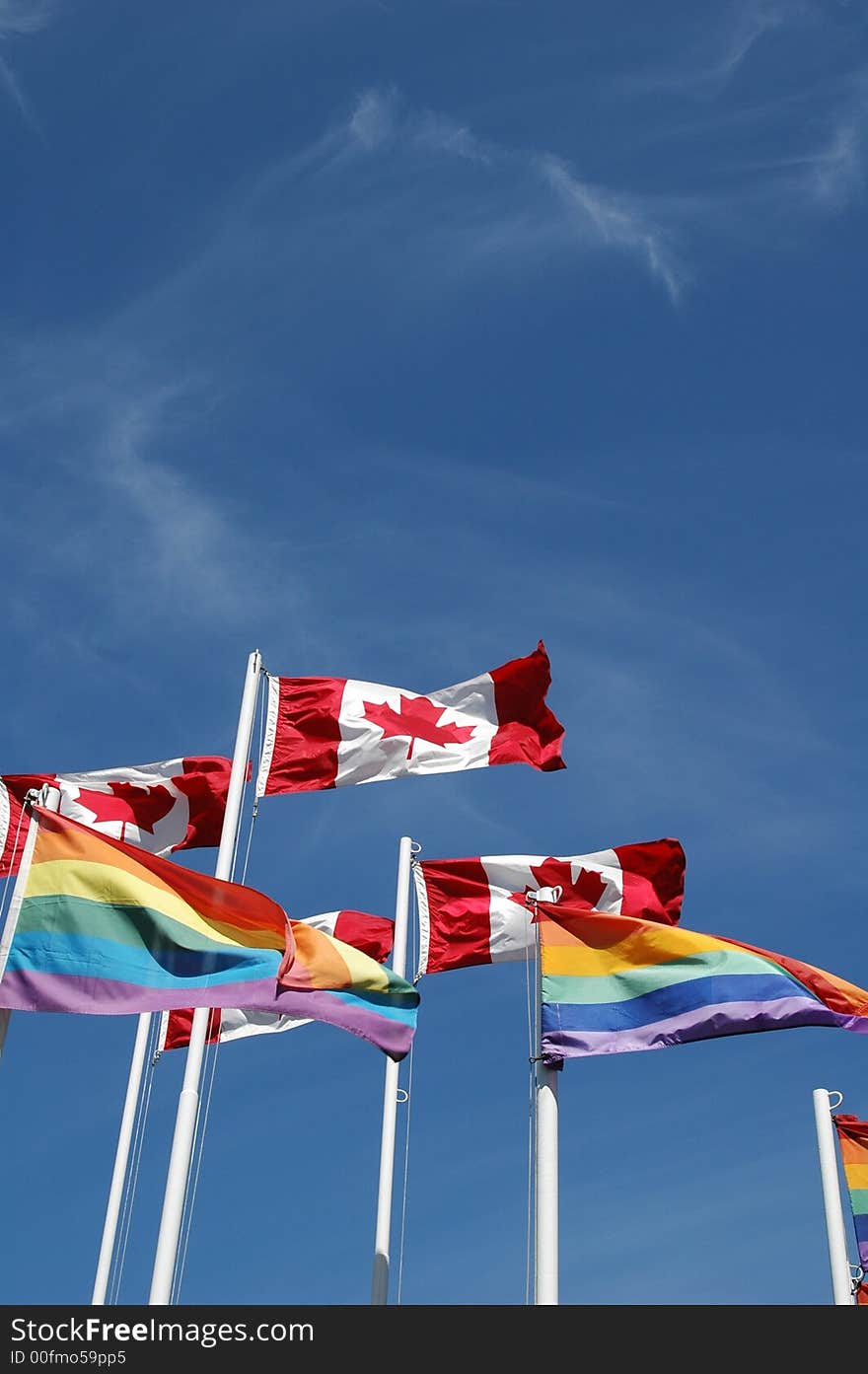 Canadian and gay pride flags fly together over English Bay, Vancouver, British Columbia, Canada. Canadian and gay pride flags fly together over English Bay, Vancouver, British Columbia, Canada