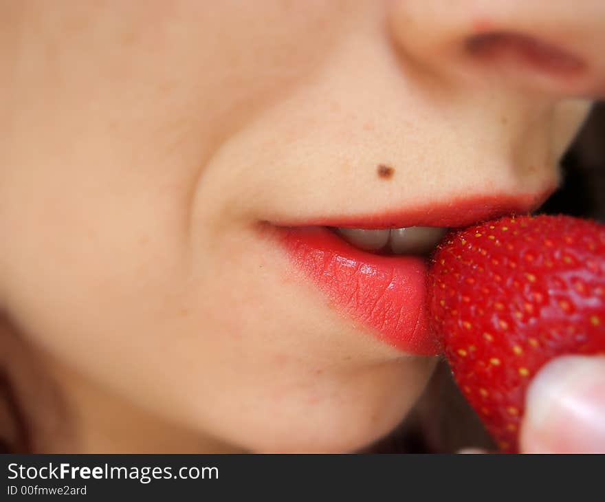 Picture of a girl tasting a strawberry. Picture of a girl tasting a strawberry