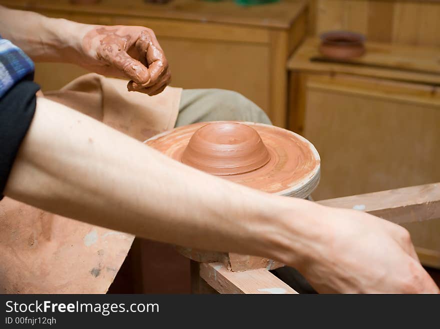 The potter on a potter's circle makes a vase