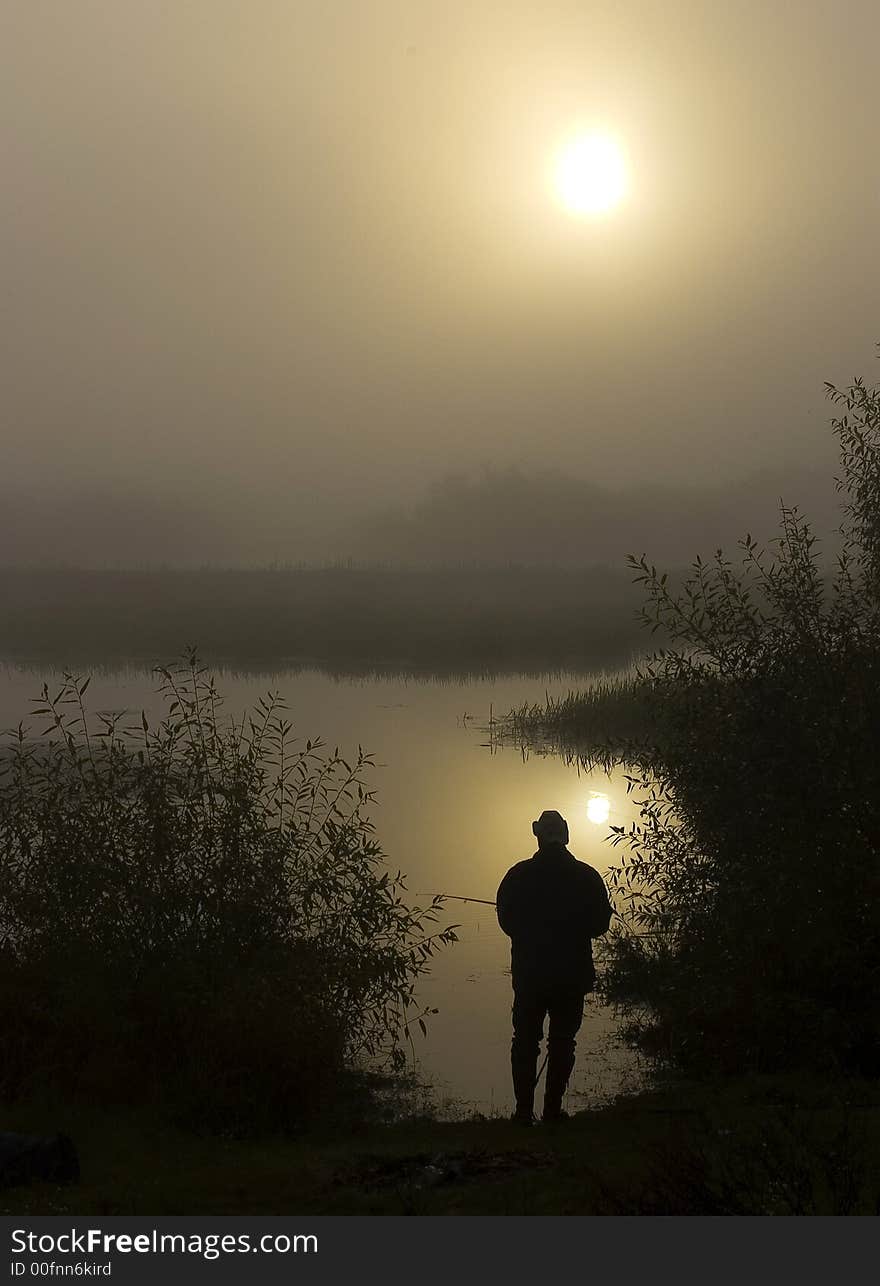 Morning on the foggy river. The person fishes. The river in Belarus. Morning on the foggy river. The person fishes. The river in Belarus