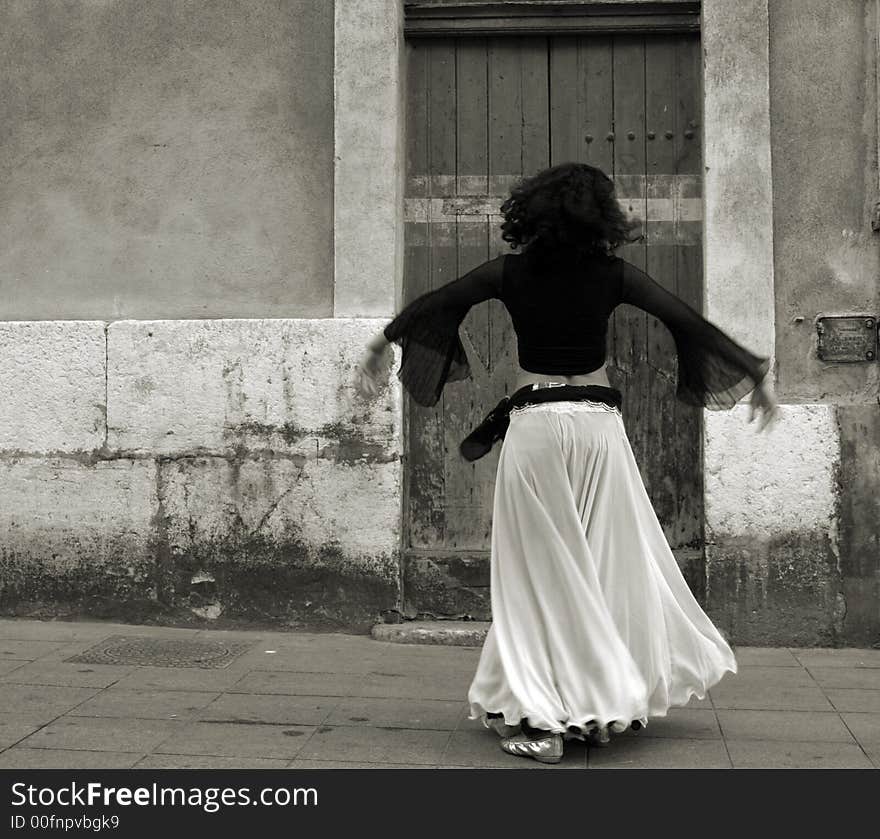 The back of a belly dancer as she dances in the street. The back of a belly dancer as she dances in the street