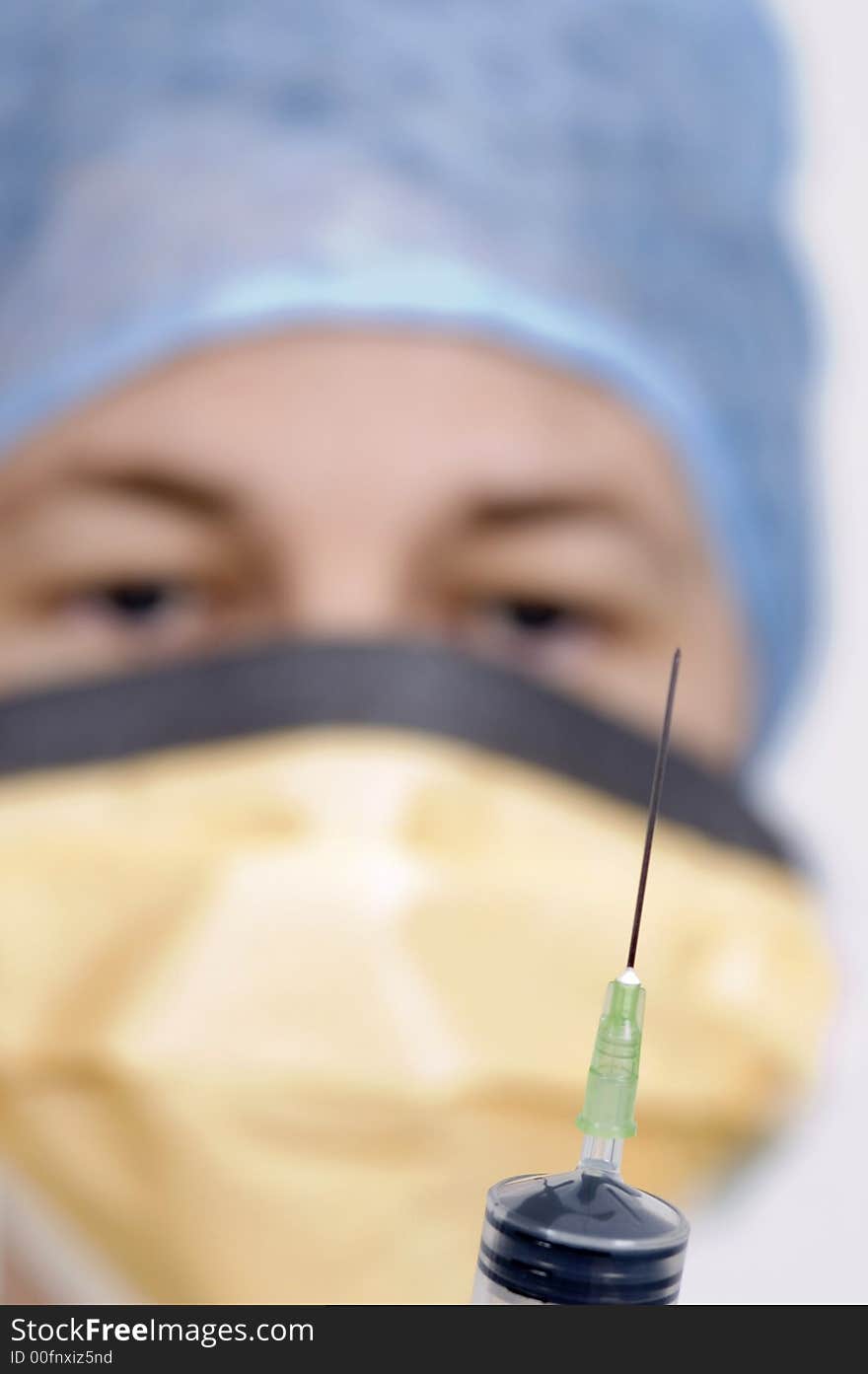 A shot of a syringe being held by a female medical practioner. A shot of a syringe being held by a female medical practioner