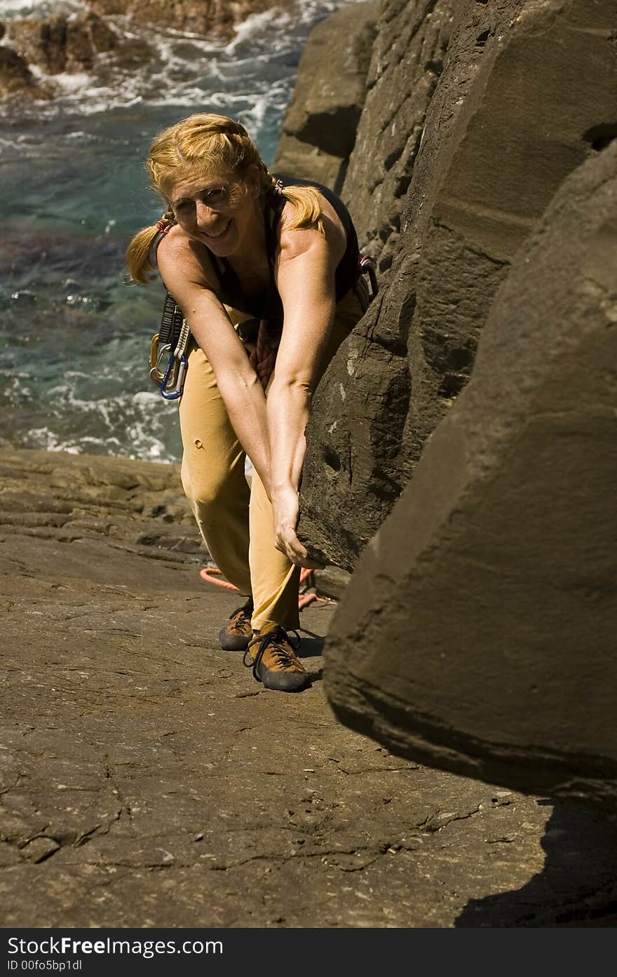 Woman scalling a sea cliff. Woman scalling a sea cliff