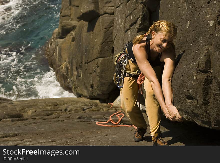 Woman climbing a large crack in a sea cliff. Woman climbing a large crack in a sea cliff