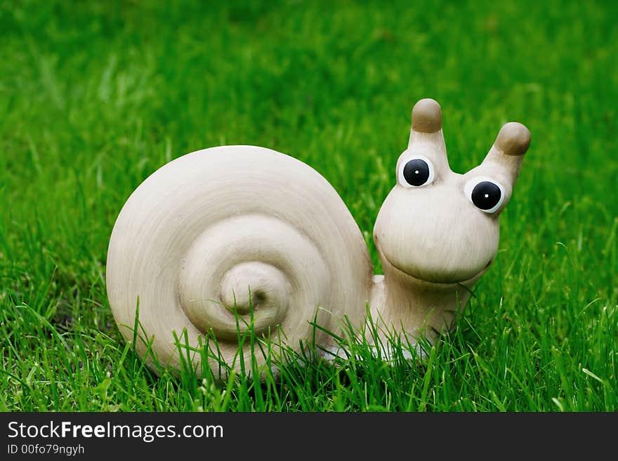 Ceramic snail in the grass, outdoor