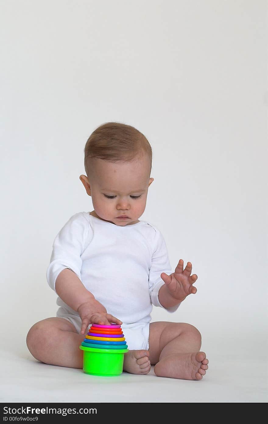 Image of an adorable baby playing with colorful stacking cups. Image of an adorable baby playing with colorful stacking cups