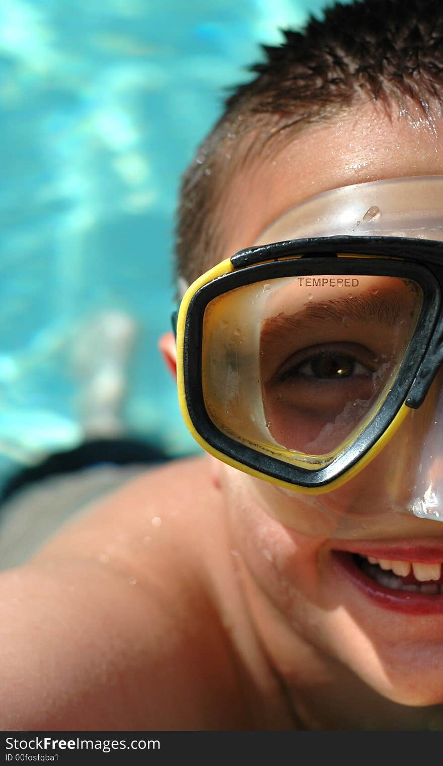 Boy in diving mask in the water; half face composition to allow for copy space. Boy in diving mask in the water; half face composition to allow for copy space